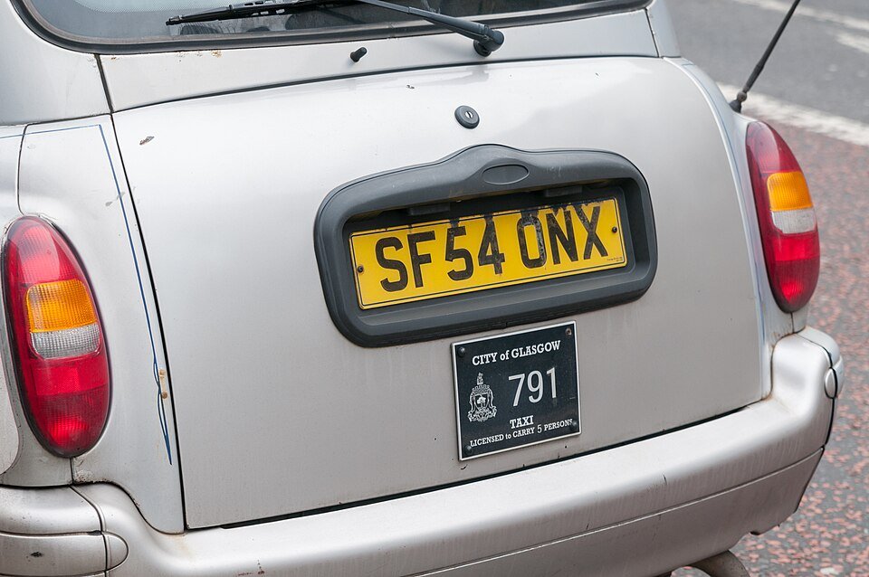 A taxi driver in a professional passenger vehicle