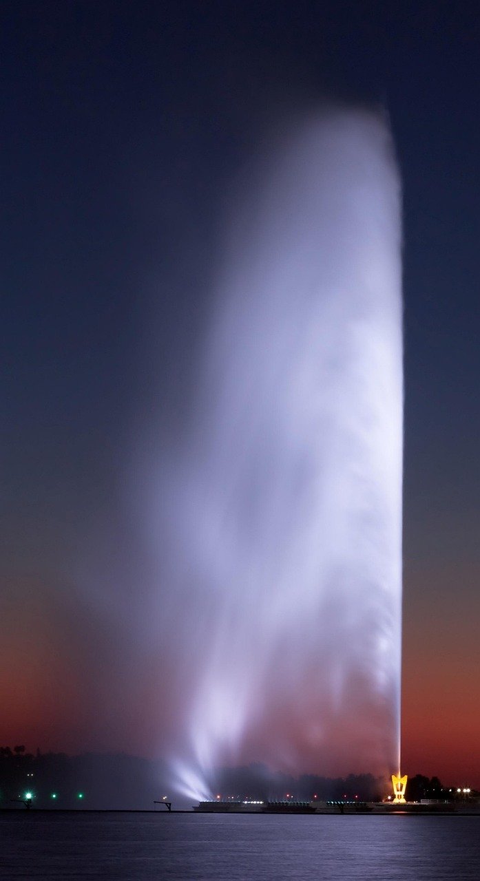 Tall water fountain spraying high into the sky, similar to Jeddah's King Fahd's Fountain