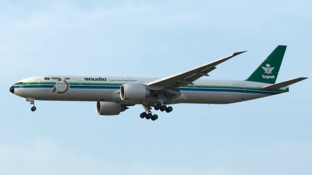 Saudia passenger jet in the air with its landing gear down