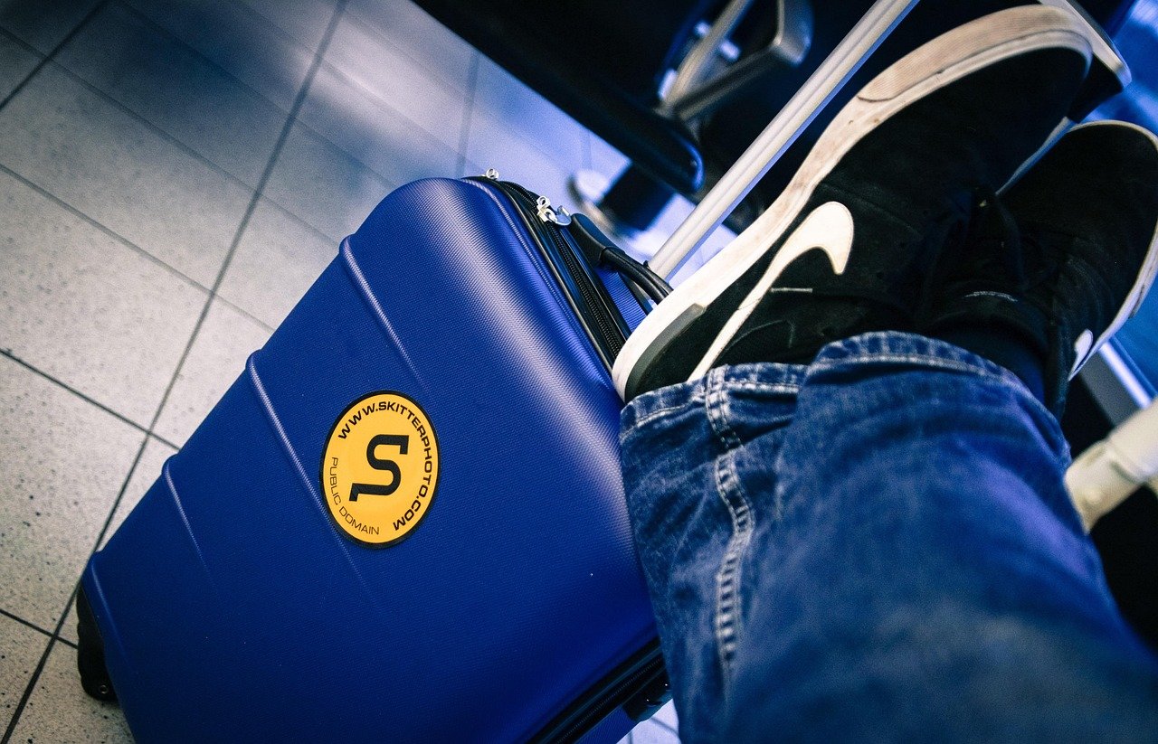 Solo business traveller with a suitcase walking through an airport arrivals area