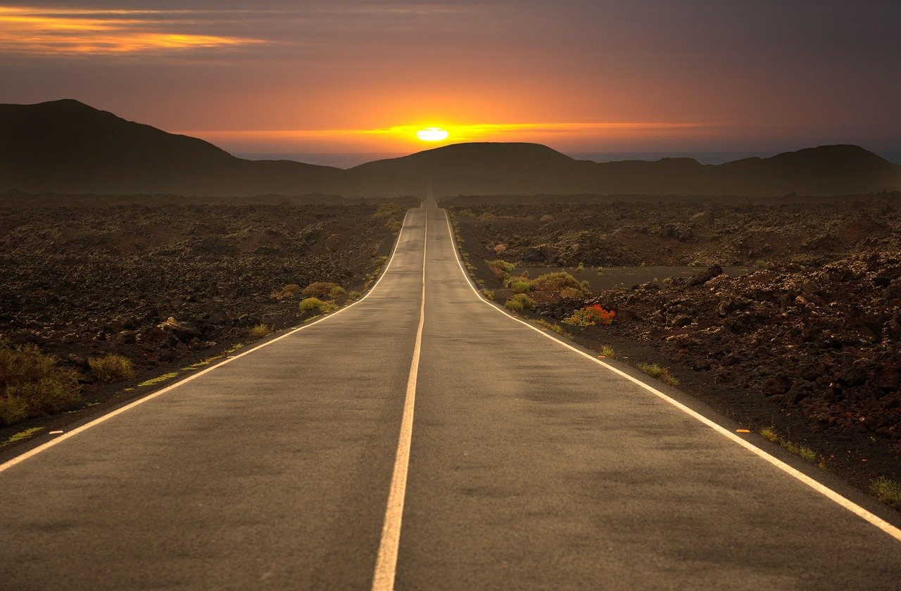 A car navigating a wide Saudi Arabian highway between cities