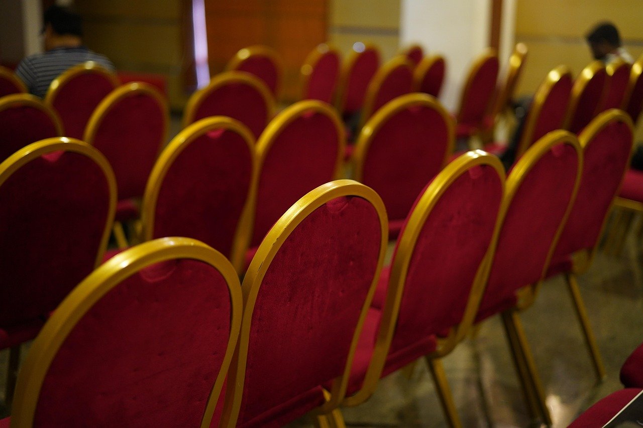 Delegates checking schedules on their phones in a hotel lobby before a conference