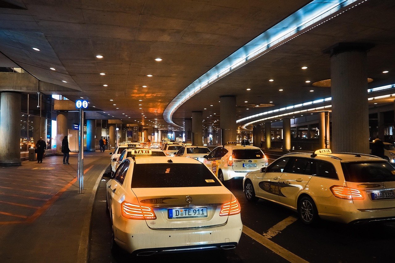 Airport terminal exterior with taxis and private cars waiting for arriving passengers