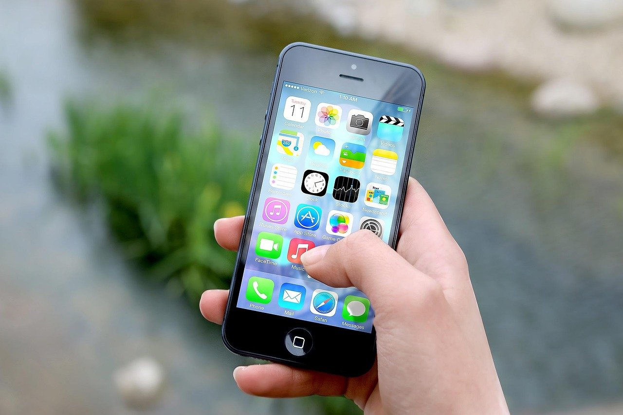 A smartphone being used to compare ride booking options (close-up detail)