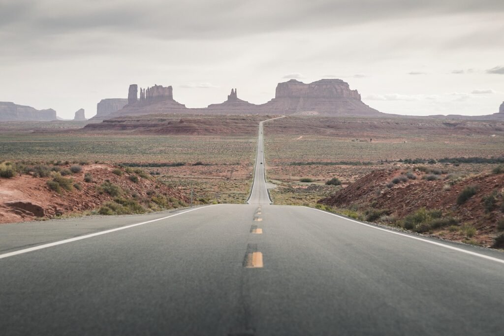 A long straight highway crossing open desert terrain typical of the route between Riyadh and Qassim