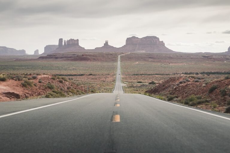 A long straight highway crossing open desert terrain typical of the route between Riyadh and Qassim