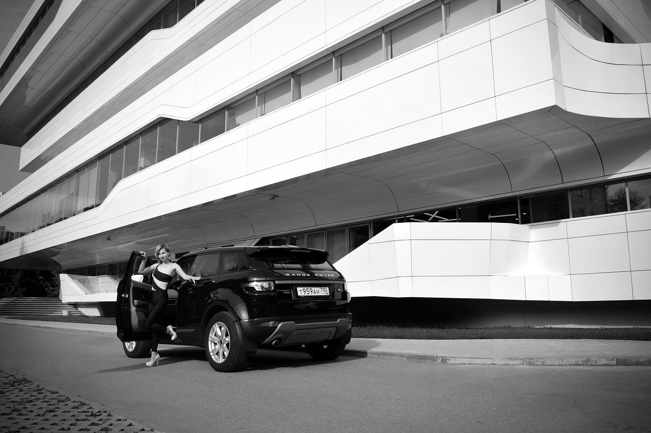 Executive sedan waiting outside a modern Saudi office building for a business meeting