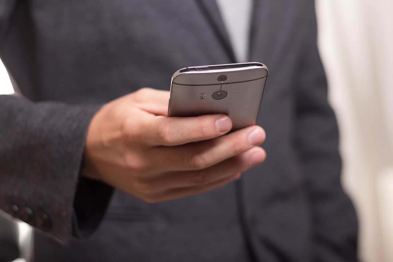 Business traveller checking a fixed price quote on a phone at a Saudi airport arrivals hall