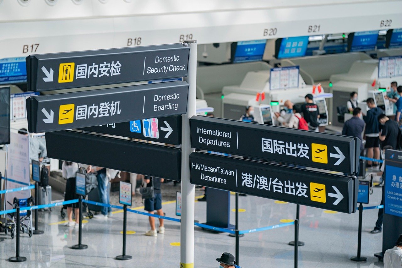 A business traveller getting into a saloon car outside an airport terminal