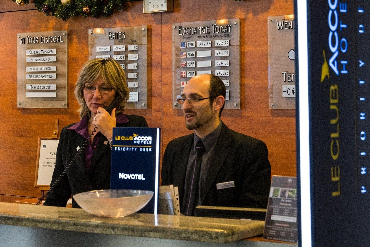 Business traveller reviewing a printed itinerary and phone at a hotel desk