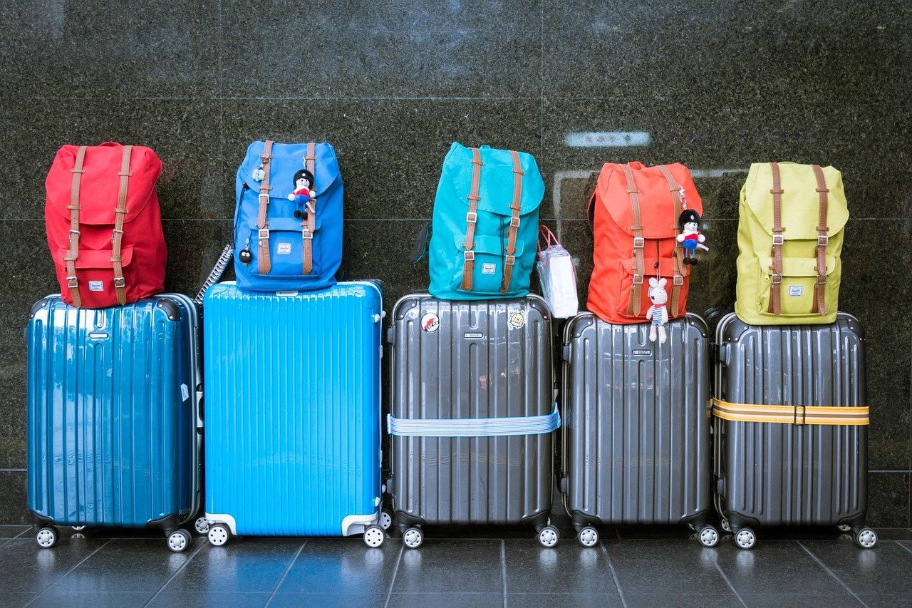 A family with luggage arriving at a Saudi airport terminal for a domestic summer trip
