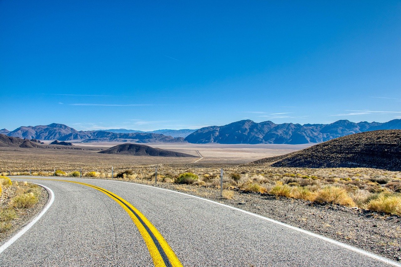 Paved road winding through a desert valley
