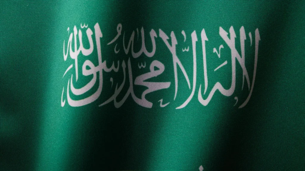 Close-up of the green Saudi Arabian flag with its white inscription and sword