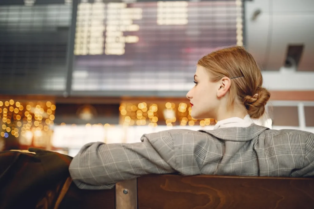 Traveller looking at a departures board in a modern airport terminal